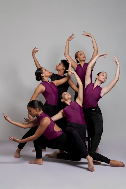 A group of young dancers striking a coordinated pose in a studio setting.